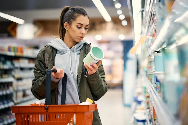 Woman checking nutrition label for fiber while shopping at Trader Joe's